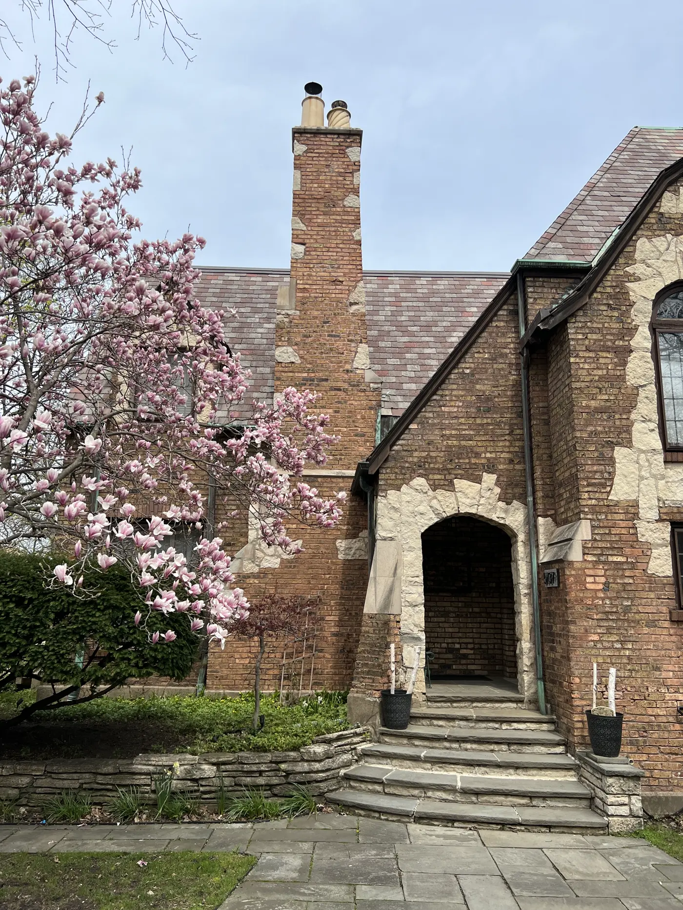 Red-brick residential chimney with visible tuckpointing and patch repair