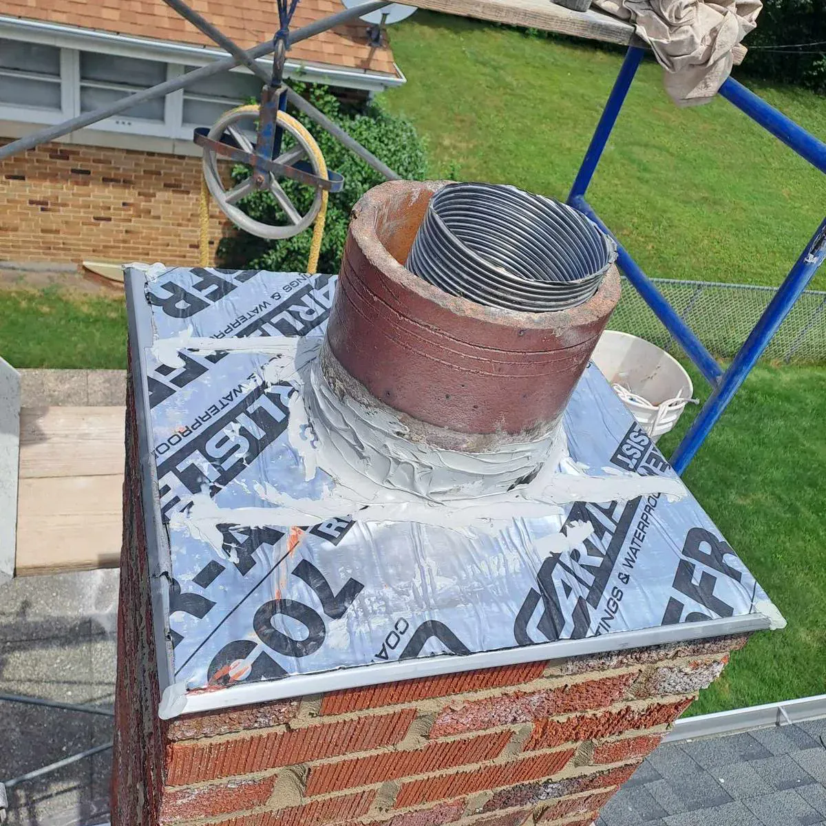 New metal chimney cap with ice and water shield flashing at the roof line